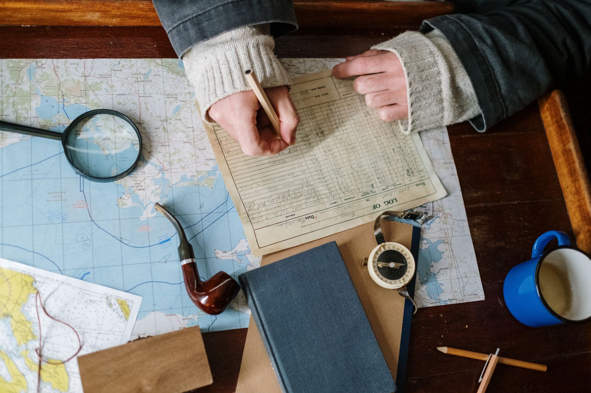 Travel writer examining ancient maps in studio